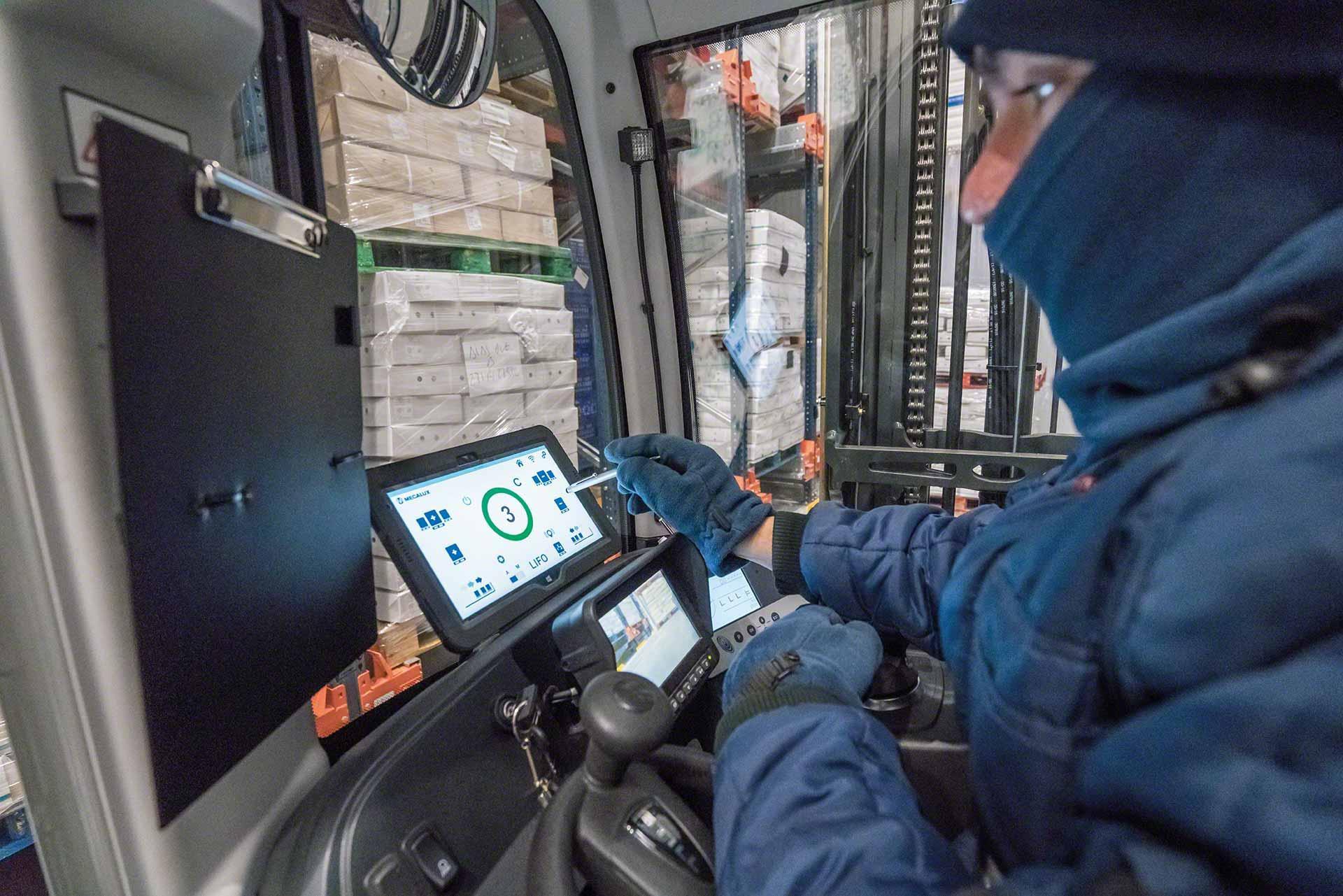 Een magazijnmedewerker maakt gebruikt van een tablet in een vrieshuis Een magazijnmedewerker maakt gebruikt van een tablet in een vrieshuis