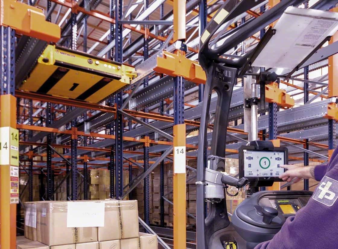 De magazijnmedewerker stuurt de semi-automatische Pallet Shuttle aan vanaf de heftruck. De magazijnmedewerker stuurt de semi-automatische Pallet Shuttle aan vanaf de heftruck.