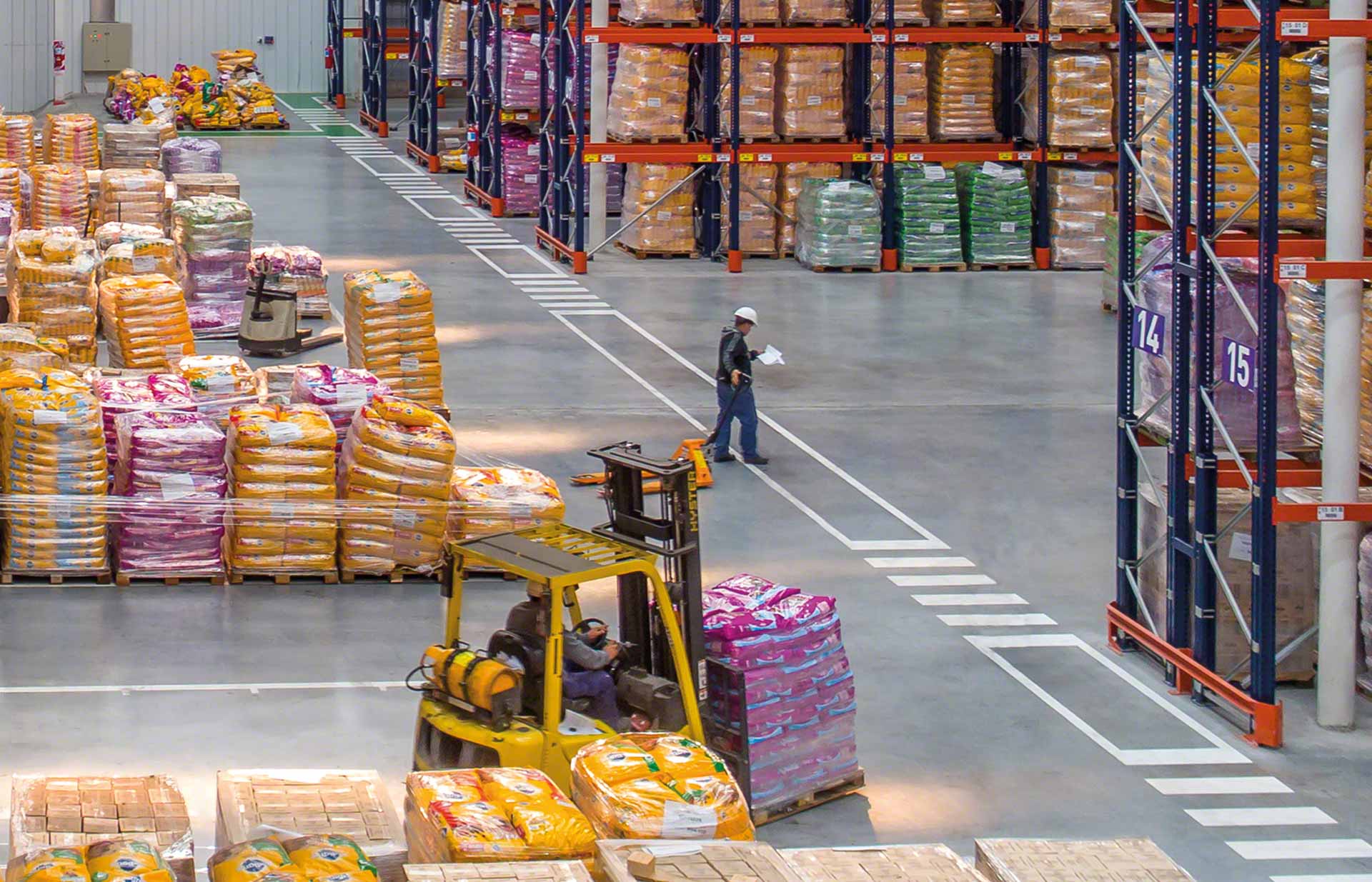 Een magazijnmedewerker coördineert de werkzaamheden in het kader van de logistieke distributie Een magazijnmedewerker coördineert de werkzaamheden in het kader van de logistieke distributie