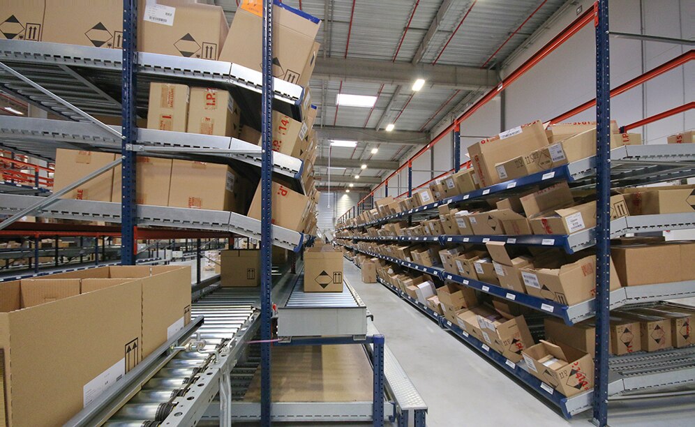 Sous l’un des rayonnages de picking circule le convoyeur continu pour les commandes terminées