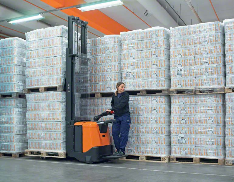 Magazijnmedewerkster op een elektrische pallettruck met staplatform bezig met opslagwerkzaamheden. (afbeelding ter beschikking gesteld door Toyota)