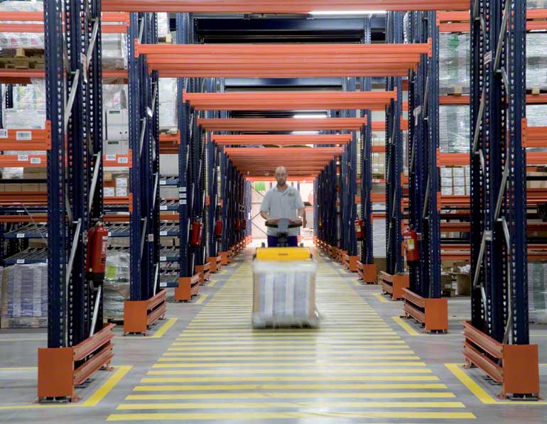 Magazijnmedewerker die een transpallet gebruikt bij de goederenafhandeling