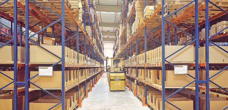 Magazijnmedewerker aan het werk in een gangpad van een conventionele magazijnstelling