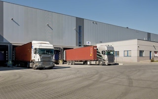 Trucks loading and unloading goods at the warehouse docks Trucks loading and unloading goods at the warehouse docks